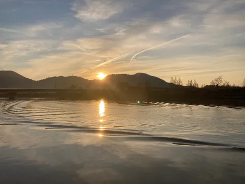 夕焼けに染まる水面、静かな水辺の風景