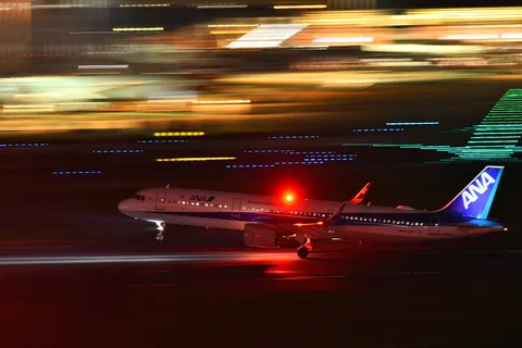 夜の滑走路、飛行機が光を纏う