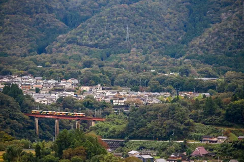 赤い橋を渡る緑の列車