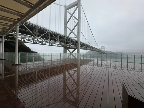霧雨に霞む吊り橋、水面に映る影