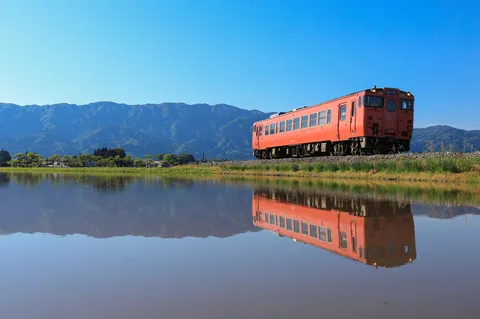 水面に映るオレンジの列車