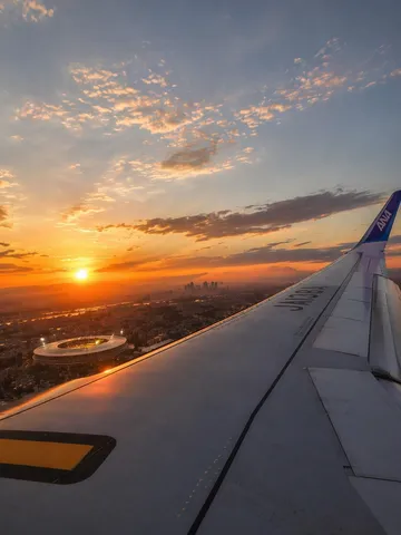飛行機から見た夕焼けとスタジアム