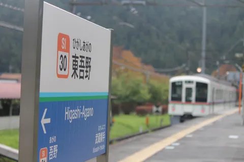 駅の案内板と秋の列車