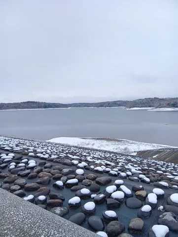 雪化粧した岩と静かな湖畔