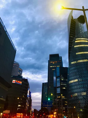 都会の灯りが灯る空