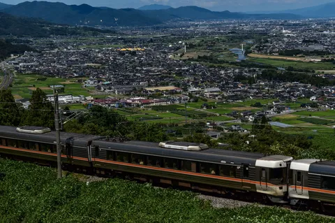 山あいの街と旅路を往く列車