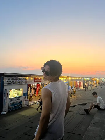 夕暮れ時の海辺、心地よい風と灯り