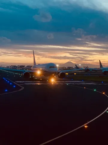 滑走路に沈む夕陽と飛行機