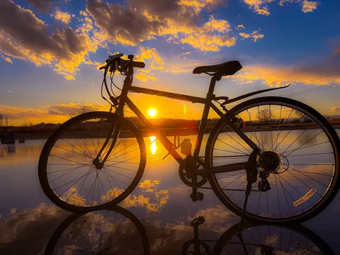 水面に溶け込む夕日の自転車