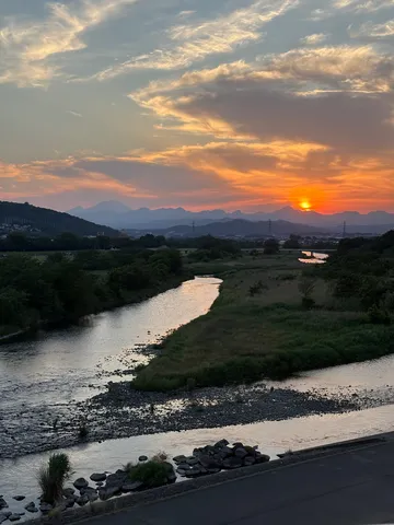 夕焼けが染まる山並みと川