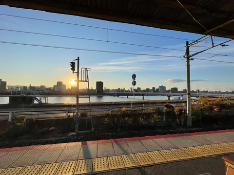 夕陽に染まる川辺の駅