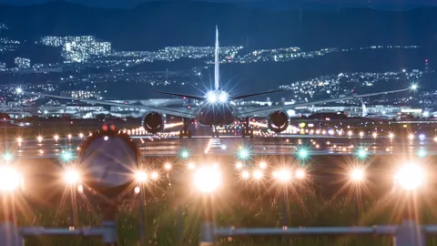 夜の滑走路、光を纏う飛行機