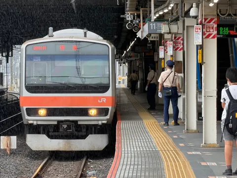 雨のホームに佇む列車