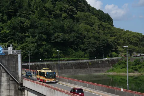 緑の山と川沿いのバス