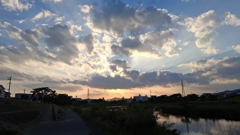 光芒が織りなす川辺の夕景
