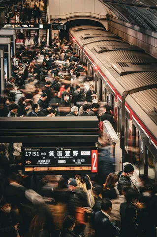 都会の駅、流れる人々の群れ