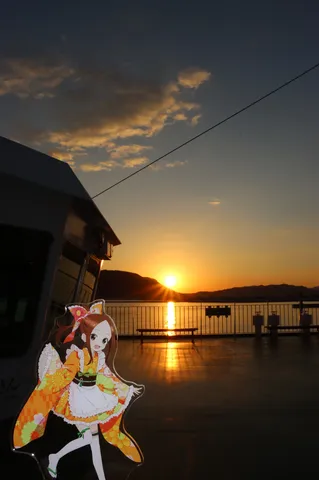 夕焼けに映える船と少女