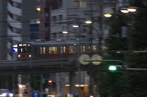 都会の夜、流れる光の電車