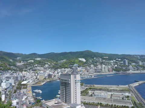 青い空と緑の山、港町の眺め