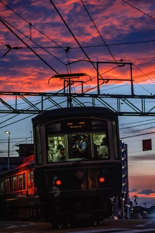 夕焼け染まる鉄路と、窓の灯り