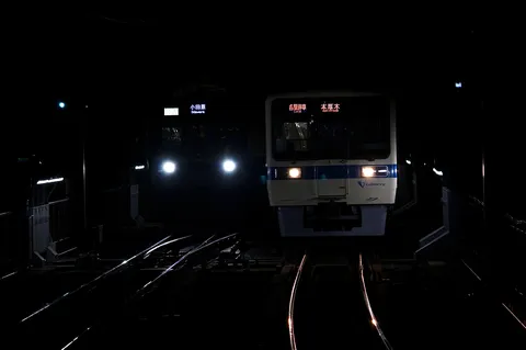夜の駅、静寂に輝くヘッドライト
