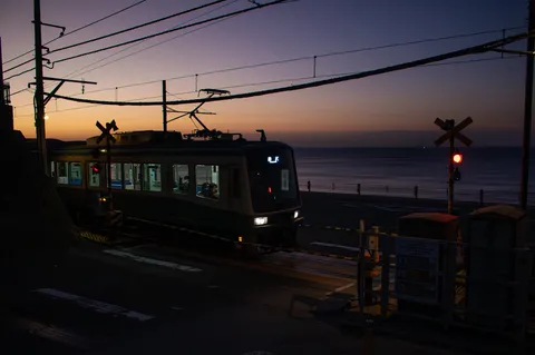夕暮れの海辺を走るローカル線