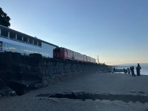 海辺を走る赤い列車の影