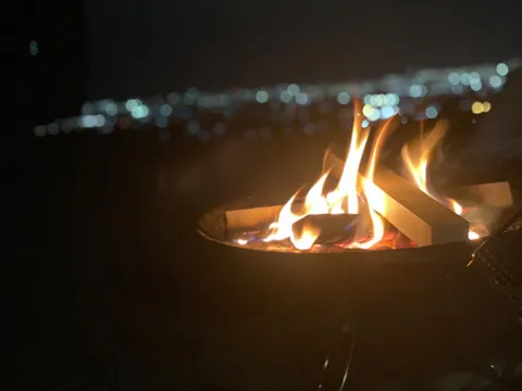 都会の夜景をバックに、炎と語らう