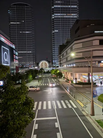 都会の夜、車のライトが照らす交差点