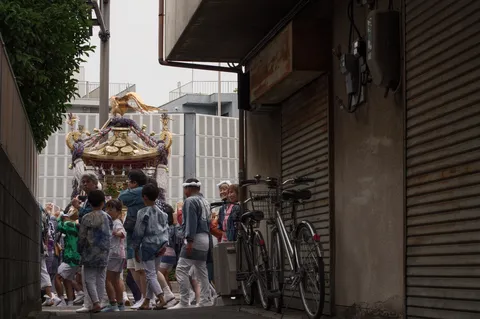路地をゆく金色の神輿
