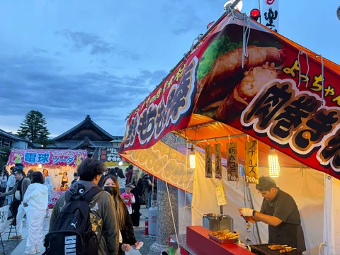 夕闇に浮かぶ屋台の賑わい