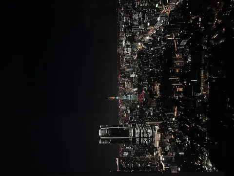 きらめく夜景に浮かぶ虹色タワー