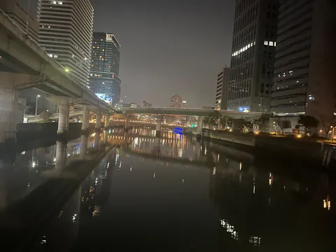 夜の水辺に映る灯りの道