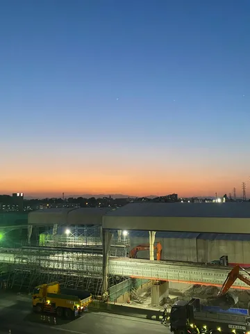 工事現場を照らす空と働く車