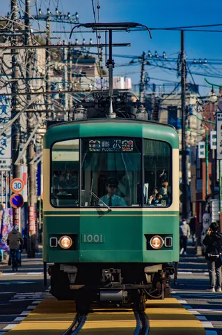 街の雑踏を行く、緑の路面電車