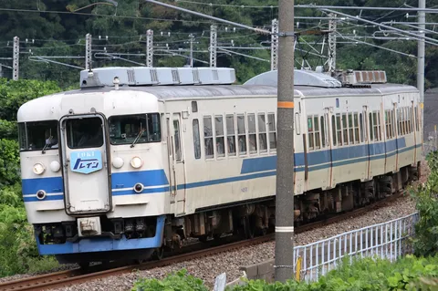 青と白の列車が描く郊外風景