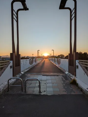 橋を渡る夕日と光の道