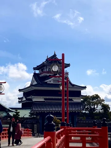 鮮やかな赤橋と古城のコントラスト