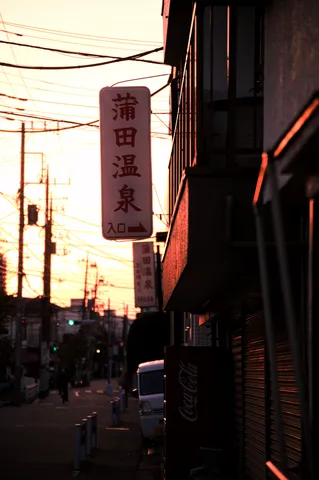 夕焼けに染まる街角の温泉案内