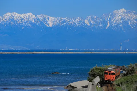 山と海とオレンジ色の列車