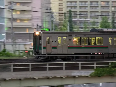 光を纏い進む銀の電車