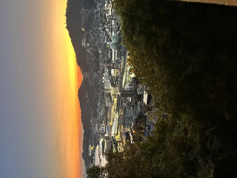 暮れゆく街の夜景と月