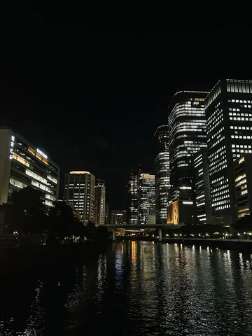 都会の夜景、水面に映る光のカーテン