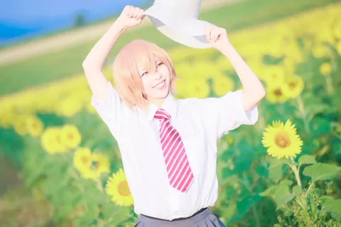 ひまわり畑で麦わら帽子をかぶる少女