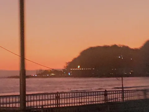 夕暮れの海辺に灯る列影