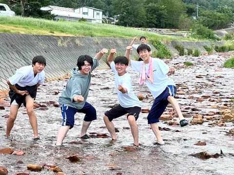 川辺の石と笑顔の跳躍