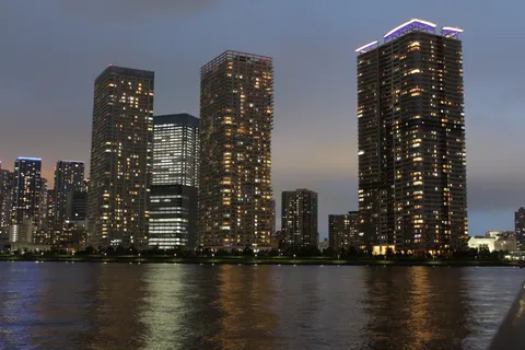 都会の夜景、水面に映る光の帯