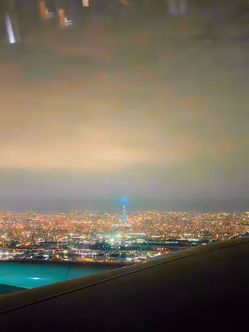 雲間から覗く都会の灯