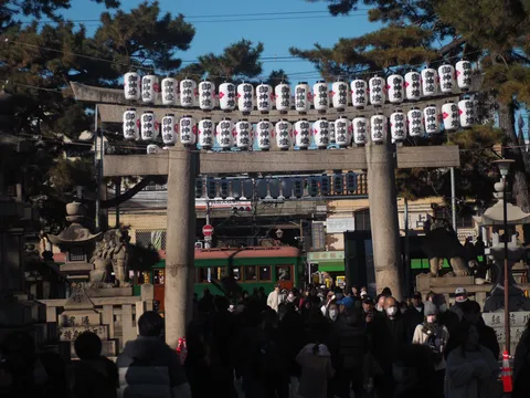 御神燈並ぶ石鳥居と人波