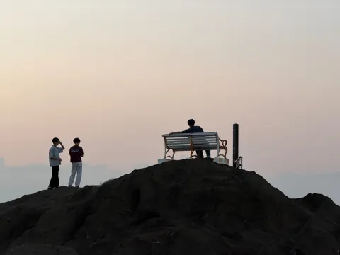 夕暮れの丘、三人のシルエット